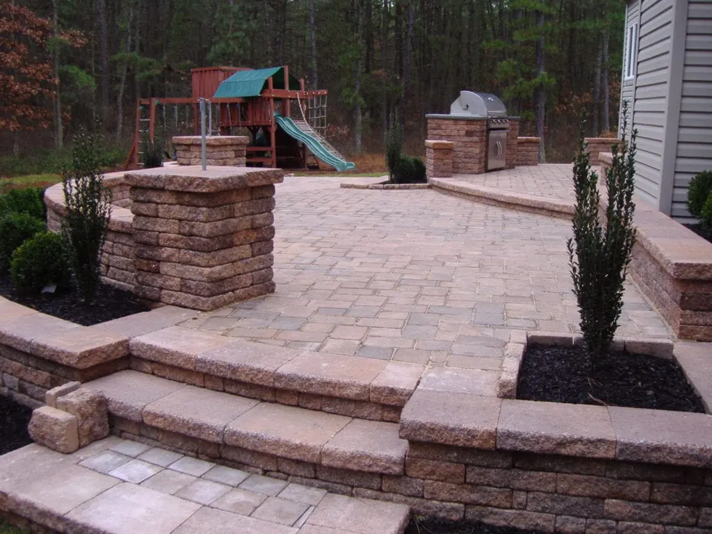 Paver patio with sitting walls, pillars and an outdoor kitchen